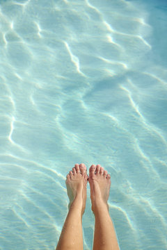 Feet of Hispanic woman floating in swimming pool at luxury resort in Palm Springs