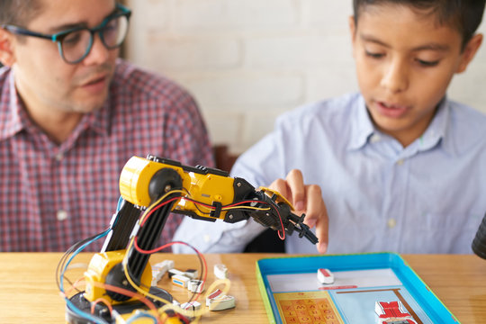 Adult and boy playing with a robot