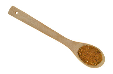 Top view of a portion of dry brown sugar and molasses marinade mix on a wood spoon isolated on a white background.