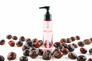 Cosmetic jar and chestnuts on white background