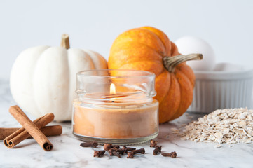 candle with pumpkin and baking ingredients