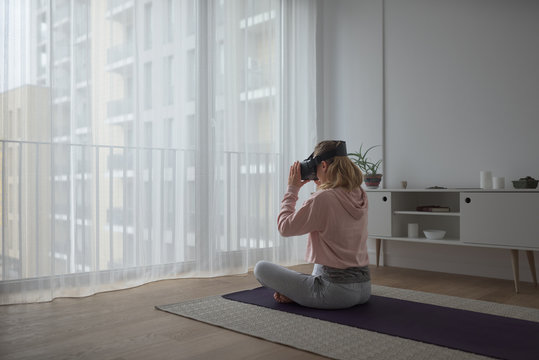 Woman practicing yoga with virtual reality gear