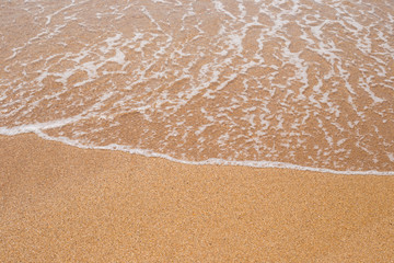 sandy beach is washed by a wave