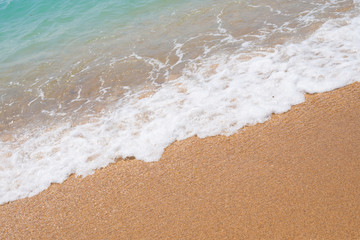 Fototapeta na wymiar wave with foam on the sandy shore
