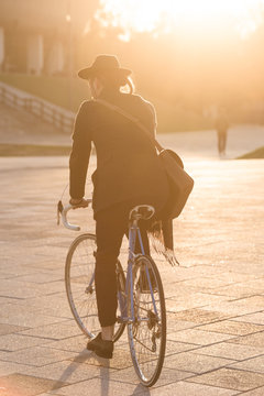 Anonymous man riding city bike in the golden hour