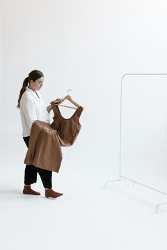 young fashion designer inspecting clothing on a hanger