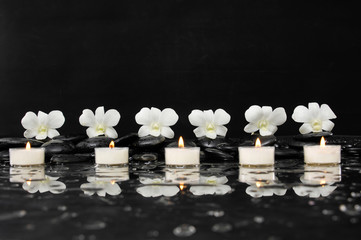 White candle with orchid and stones 