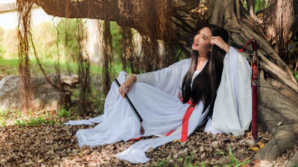 Beautiful Chinese woman with a traditional suit with a flute in her hands, Beautiful and...