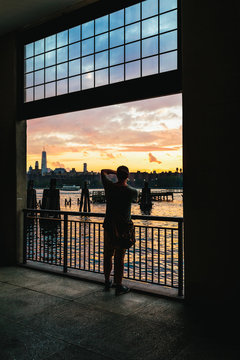 Silhouette of a Man Taking a Picture of a New York Sunset