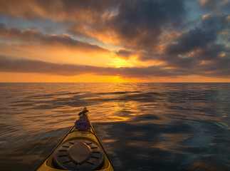 The bow of the sea kayak on the background of a beautiful sea sunset.