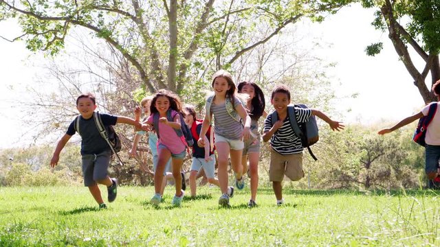 Group Of Children With Friends In Park Running Towards Camera Shot In Slow Motion