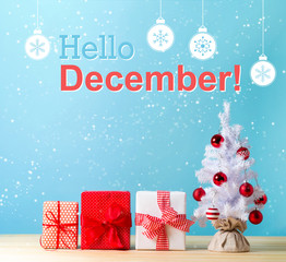 Hello December message with a white Christmas tree and gift boxes © Tierney