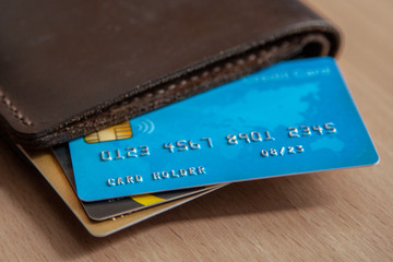 Credit cards in a wallet on wooden table. Open access for online shopping - obrazy, fototapety, plakaty