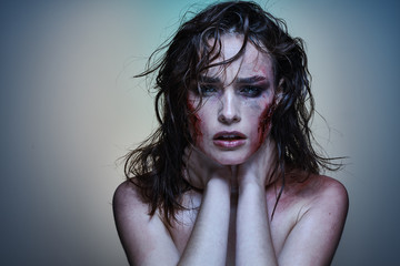 Beautiful girl with a wounded face in the blood