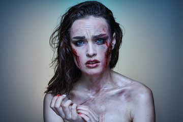Beautiful girl with a wounded face in the blood