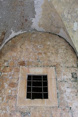 old barred window in stone wall
