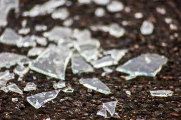 Fragments of transparent glass on asphalt