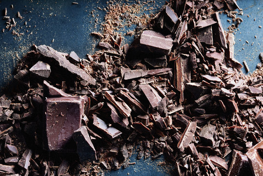 Chocolate. Shards of chopped chocolate on metal background.