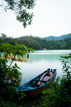 A rowboat on the edge of a volcanic lake in Indonesia