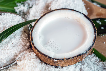 fresh coconut milk in coconut bowl on green leaf background  © doucefleur