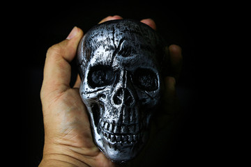 Skull Halloween dark scary horror story ideas concept with human hand isolated on black background