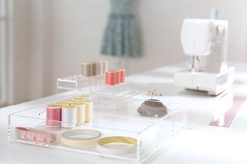 thread in spools, measuring tape and sewing machine