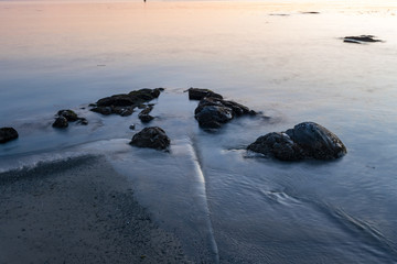 Fototapeta na wymiar waves washing the rocks on the beach after sunset