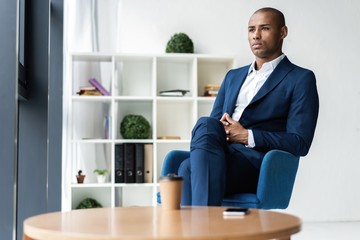 Handsome cheerful african american executive business man at the workspace office.