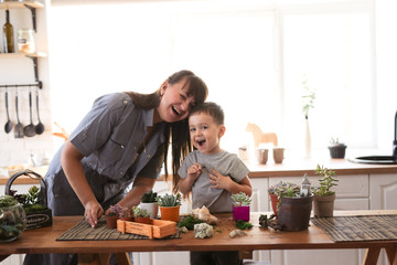 Mom and son cheerful emotional take care of plants