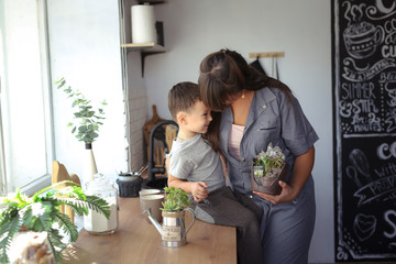 Mom and son cheerful emotional take care of plants