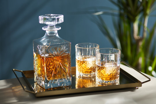 Composition of crystal bottle and two rocks on tray.