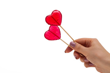 sweet heart shaped lollipops in hand, isolate