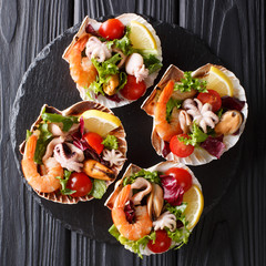 Restaurant gourmet seafood salad of shrimp, baby octopus, mussels, squid and scallops in sea shells...