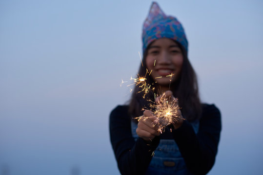 Happy Young Woman Playing With A Sparkler