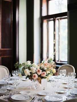 A beautiful wedding table setting with a floral composition with punk and white flowers