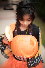 little girls holding a pumpkins
