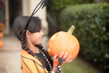 little girls holding a pumpkins