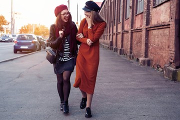 Outdoors fashion portrait young pretty best girls friends in friendly hug. Walking at the city....