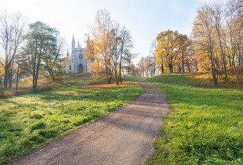 autumn landscape, a Catholic chapel among the trees with yellow leaves ,the path up the hill to the chapel