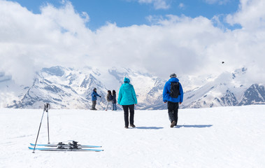 people, skiers in the Caucasus mountains in winter, mountain slopes and peaks covered with snow
