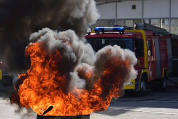 Fire in front of fire truck during demonstrative exercise of firemen skills