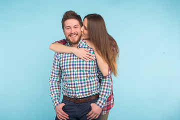 Portrait of cheerful laughing funny young lovers fooling around on blue background