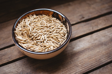 top view a bowl of oat grains on a wooden background, natural food