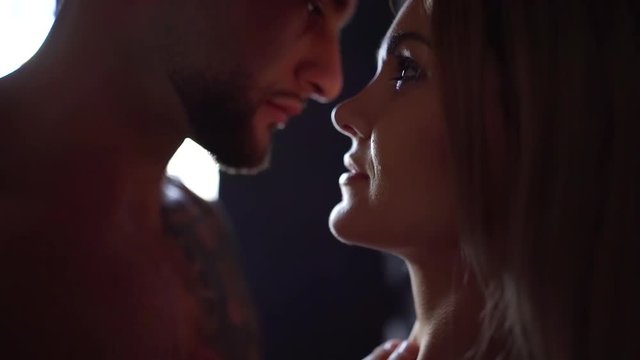 strong guy is touching face of his agitated girlfriend, view from his shoulder