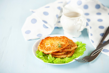 Potato pancakes with salad on a blue background. Selective focus. Rösti . Swiss national dish.