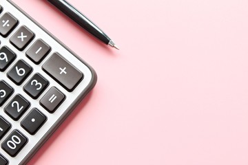 Business, finance, savings money, investment, taxes or accounting concept : Top view or flat lay of calculator and pen on pink background with copy space ready for adding or mock up