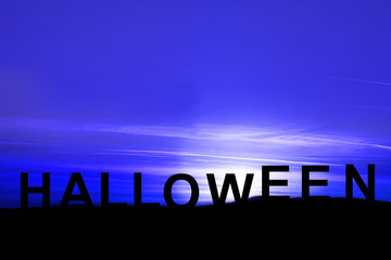 silhouette sunset view with words halloween on the mountain