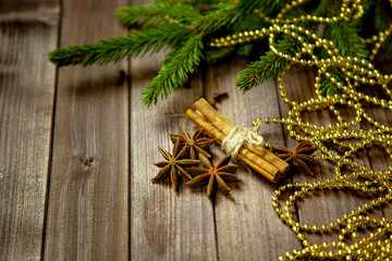 Spices for mulled wine with Christmas tree on wooden background