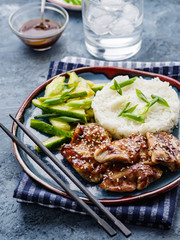 Hoisin Chicken. Traditional Asian cuisine. Chicken with sauce, rice and pickled cucumbers.