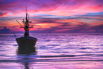 Silhouette of fishing boat in tropical sea at beautiful sunrise, Ultra violet, pink twilight sky background.Color of the year 2018 ultra violet pantone.